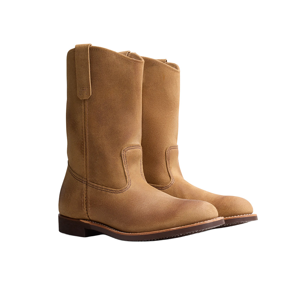 Pair of tan boots on a white background