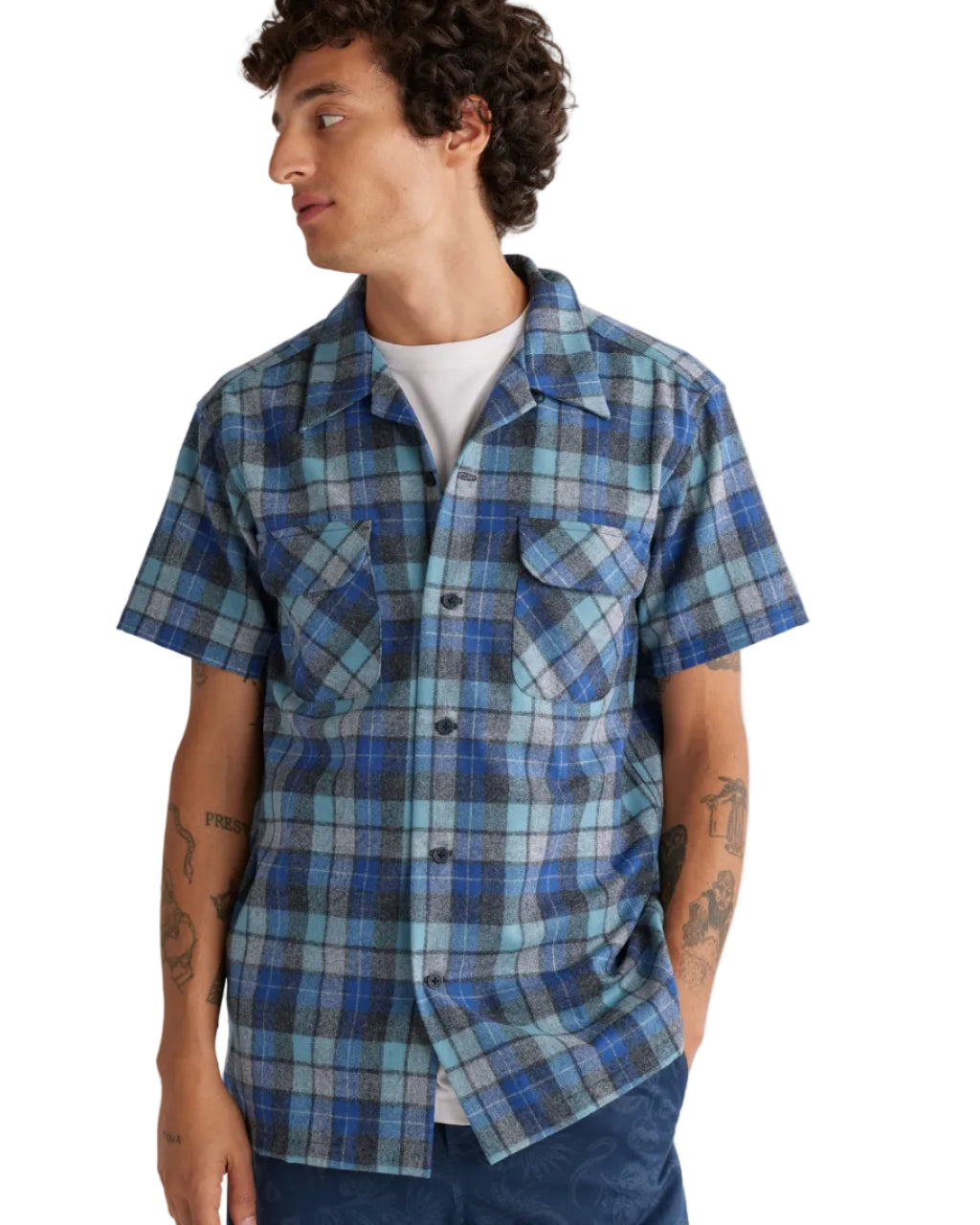 Person wearing a blue plaid shirt with short sleeves on a plain background