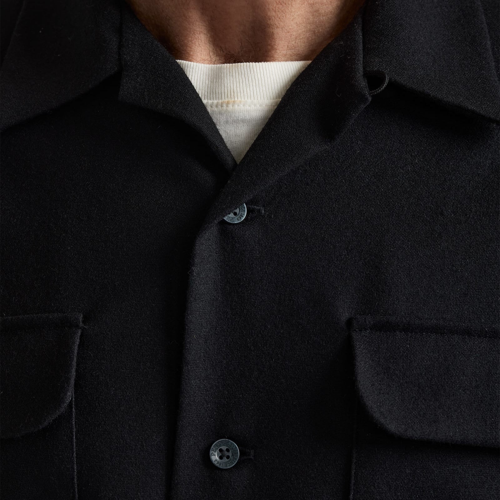 Close-up of a dark shirt with a button detail