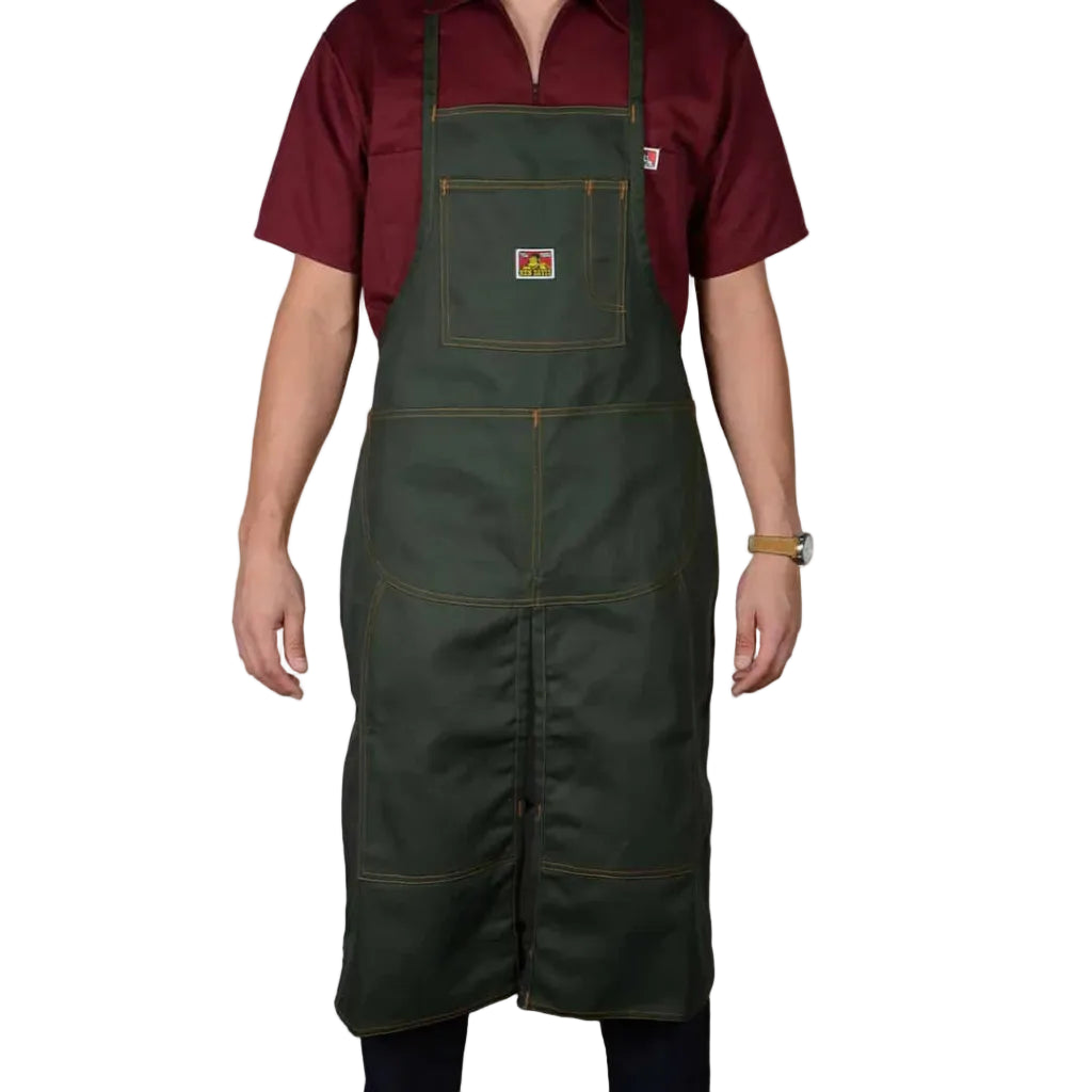 Person wearing a green apron over a red shirt on a white background