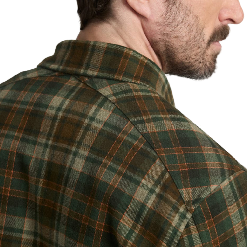 Man wearing a green plaid shirt against a plain background