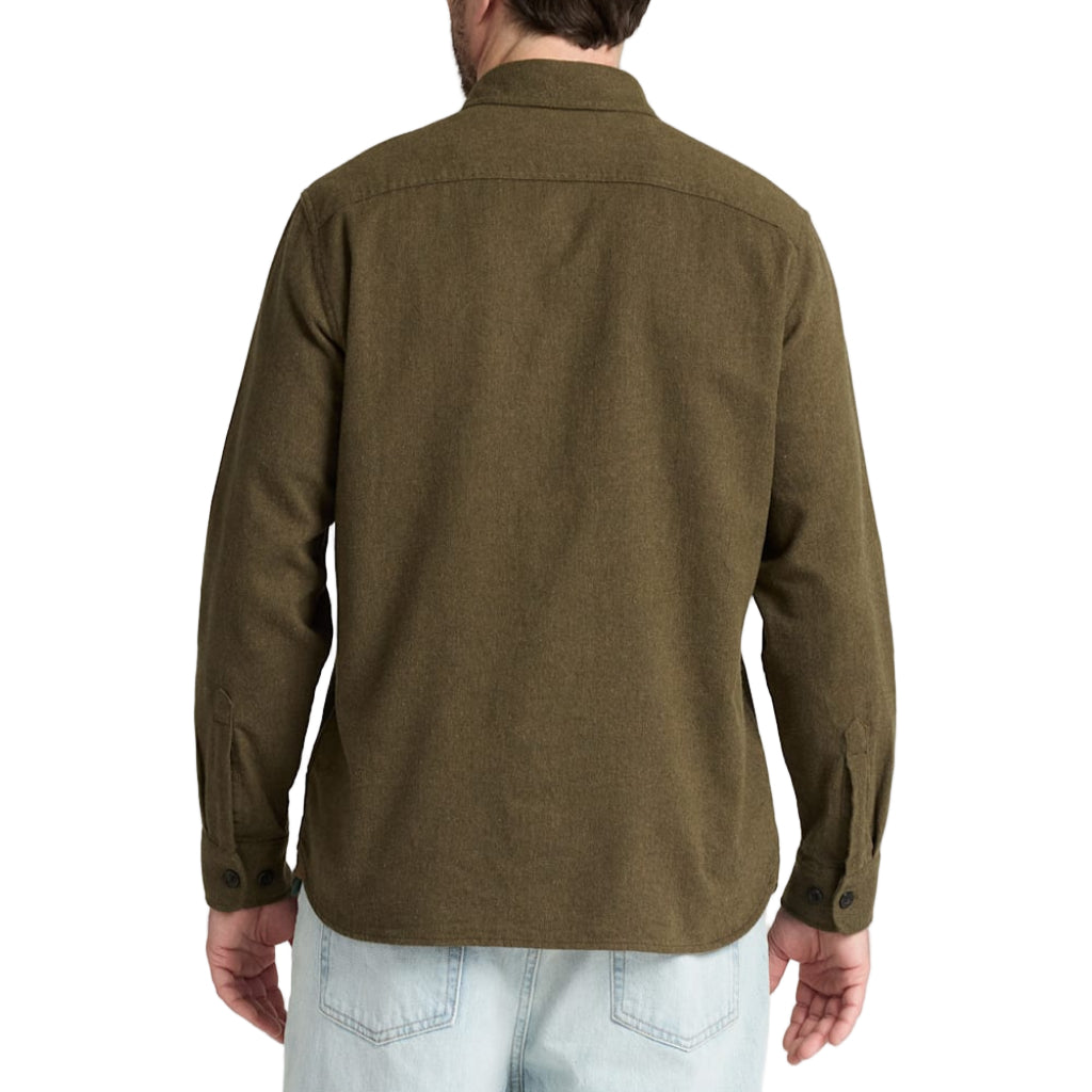 Man wearing a green shirt and light blue jeans on a white background