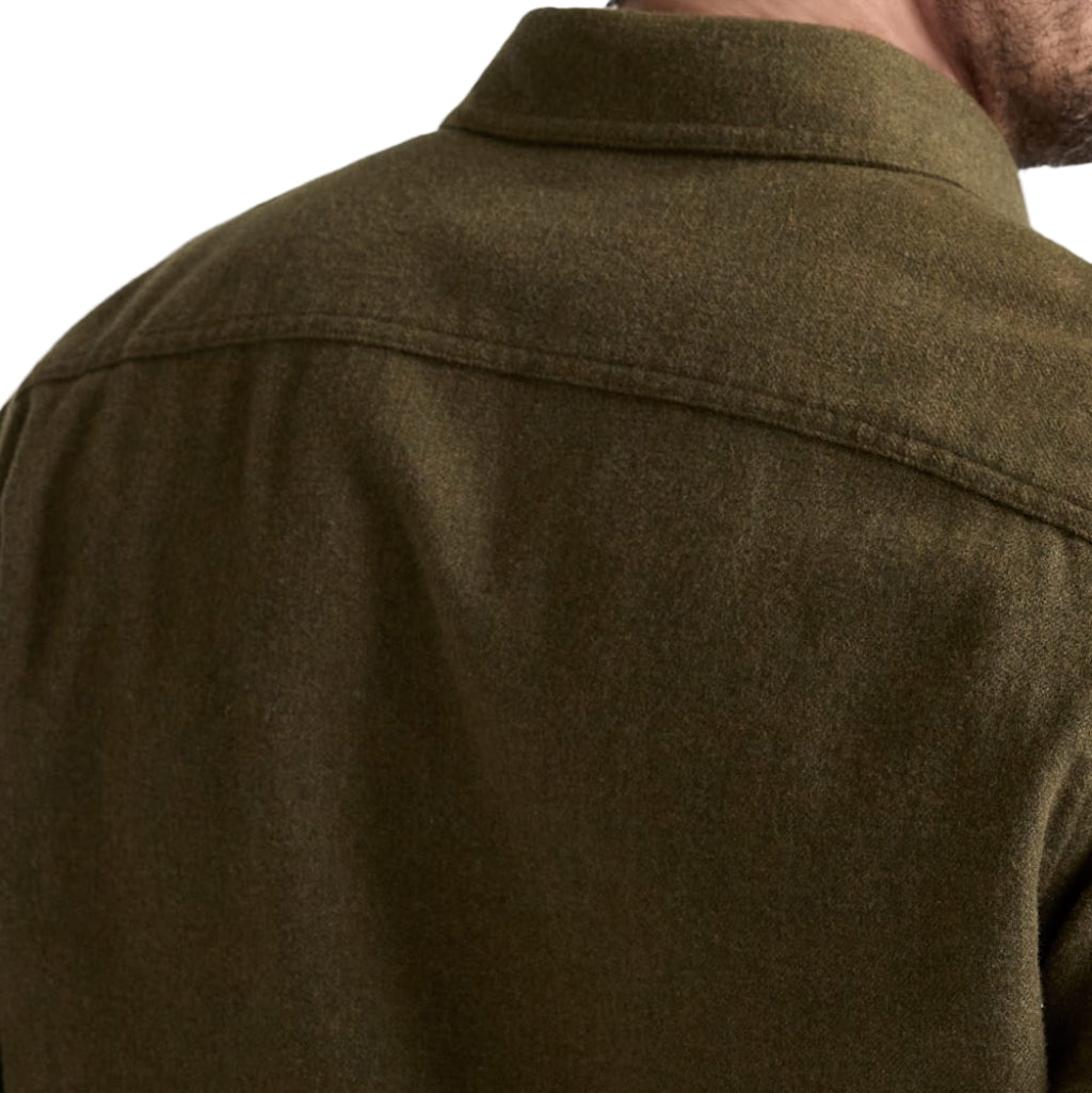 Close-up of a person wearing a green shirt with a neutral background