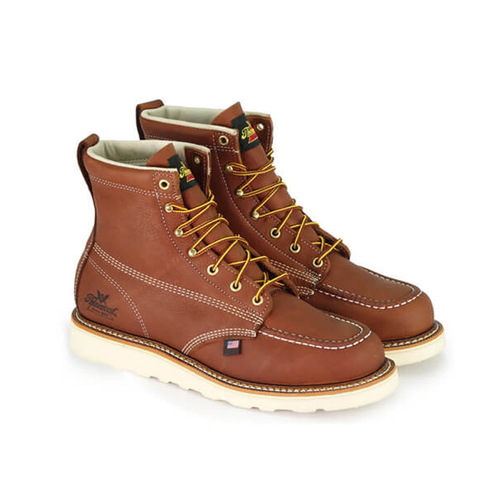 A pair of brown Thorogood boots with lace-up closure, featuring a moc toe style and a white sole.