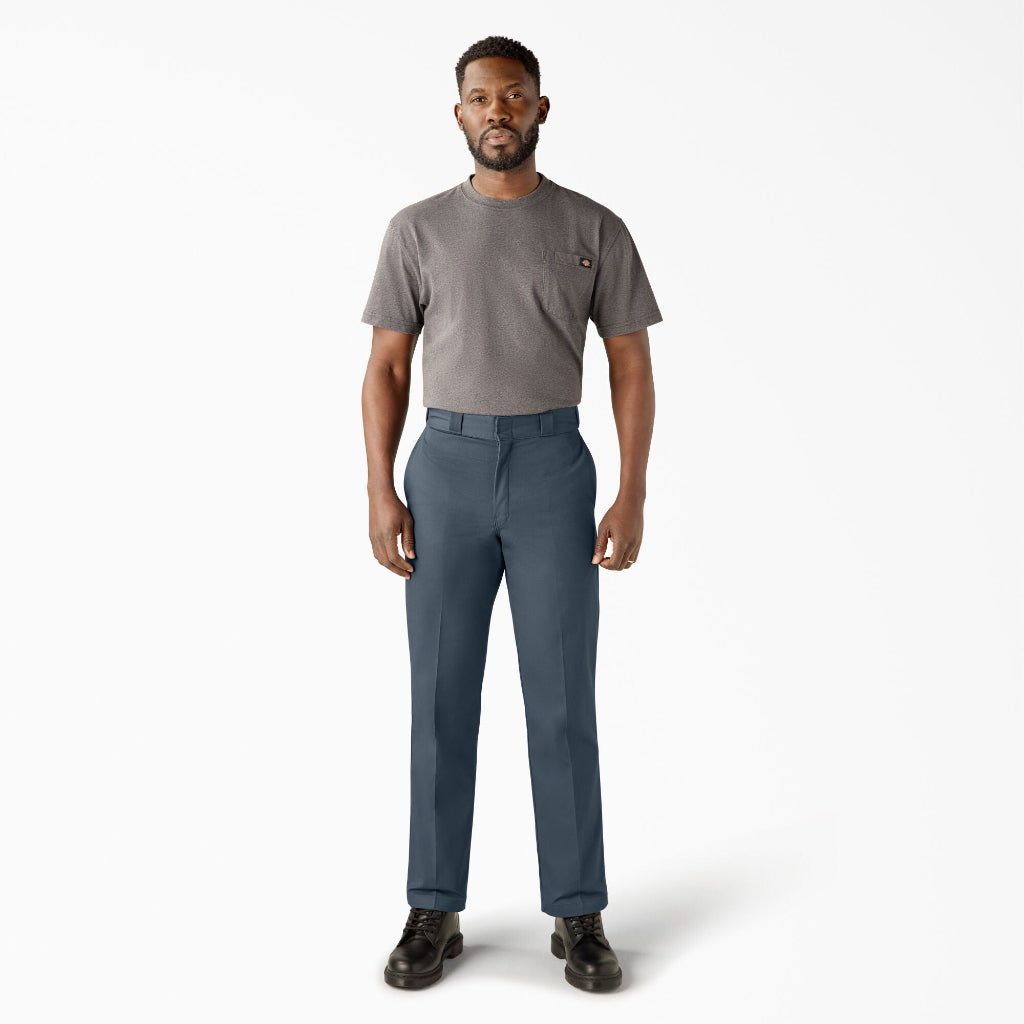 Man wearing a gray t-shirt and blue pants on a white background