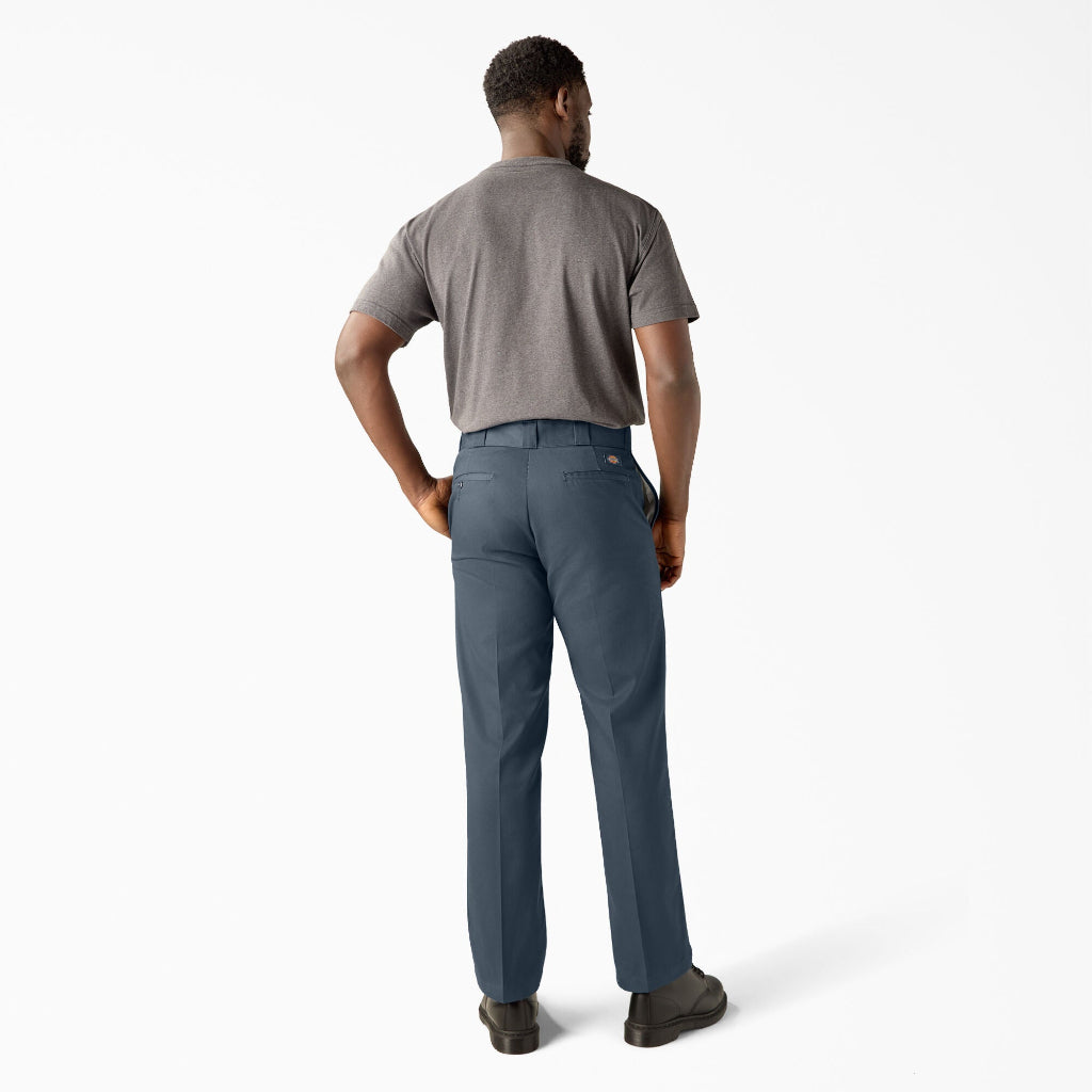Man wearing gray t-shirt and blue pants on a white background