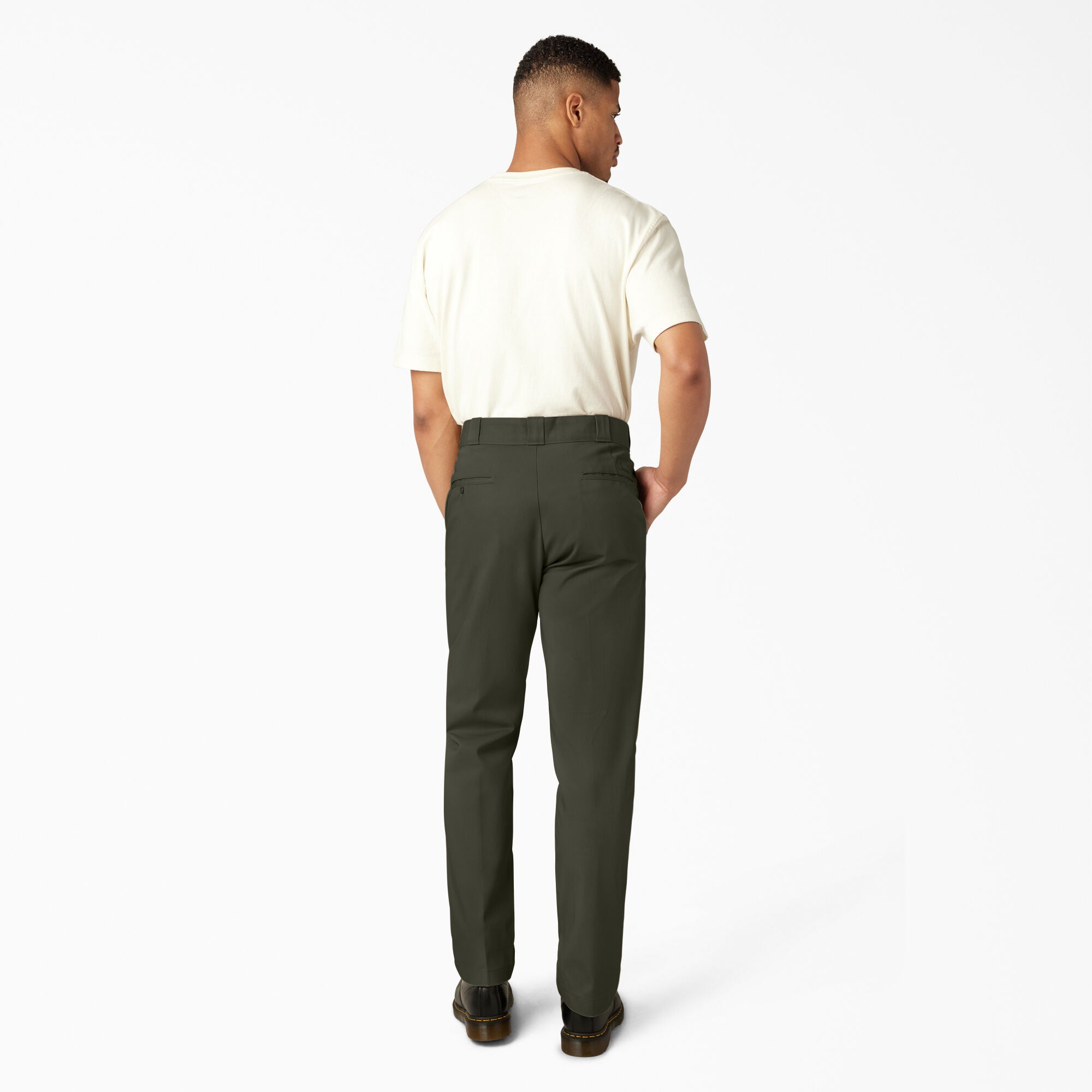 Man wearing a white shirt and green pants on a white background