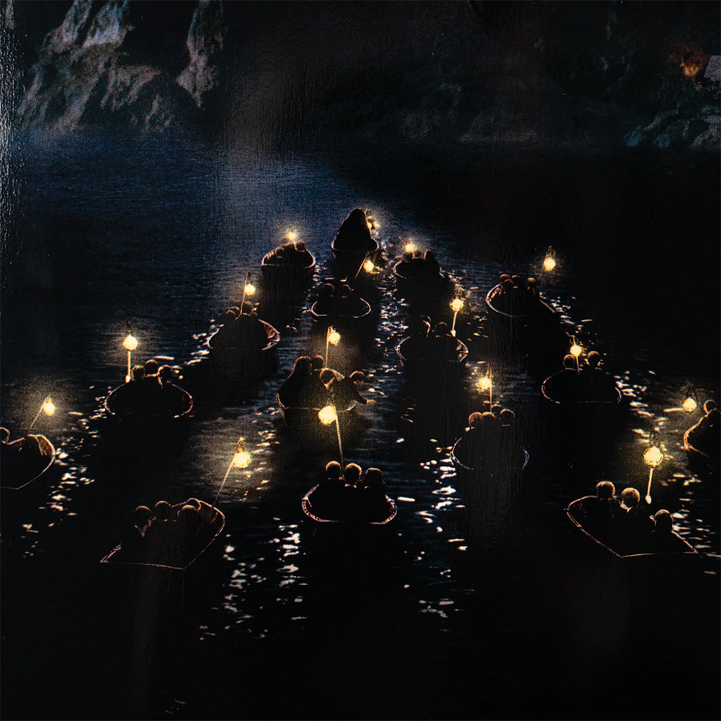 Candles floating on water in a dark cave