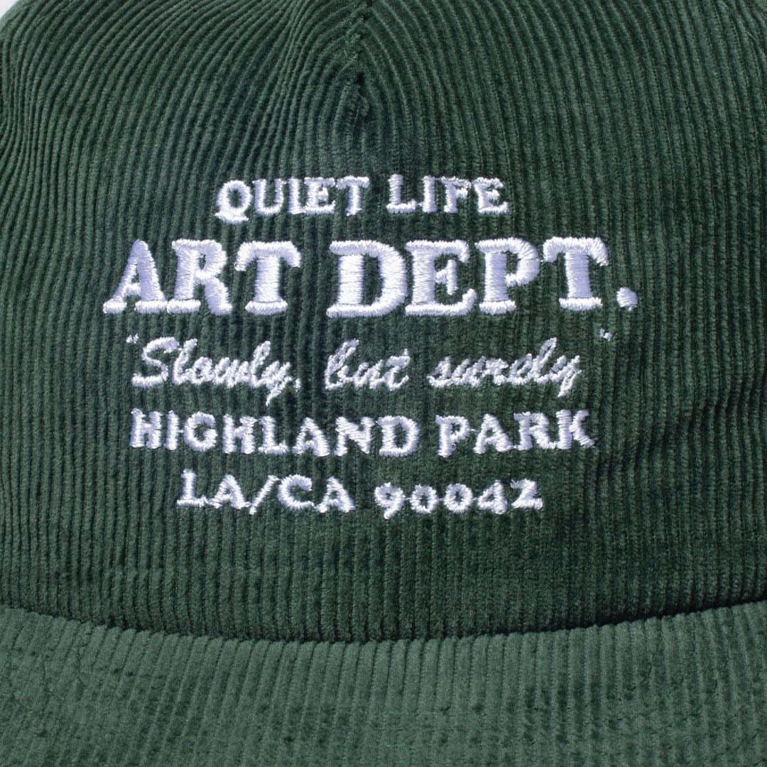 Green cap with white embroidered text on a green background
