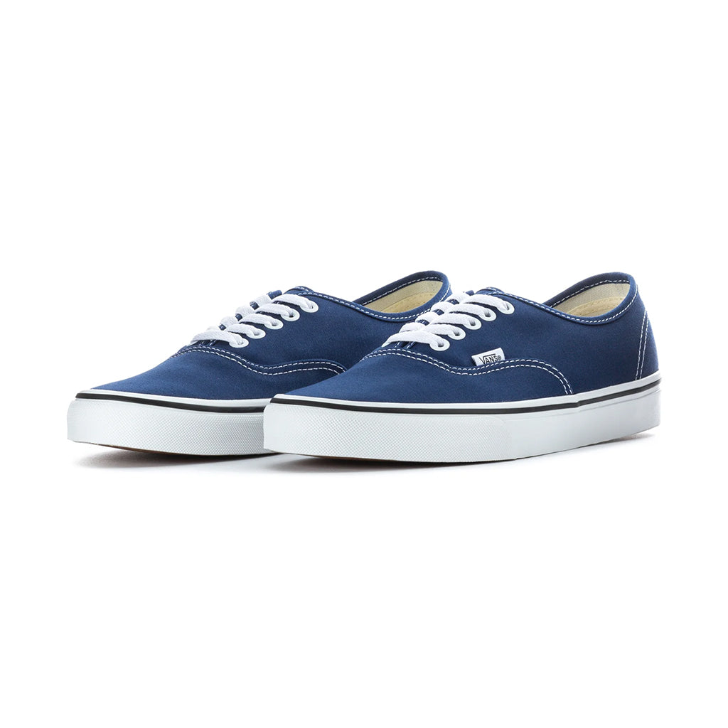 Pair of blue sneakers with white laces on a white background