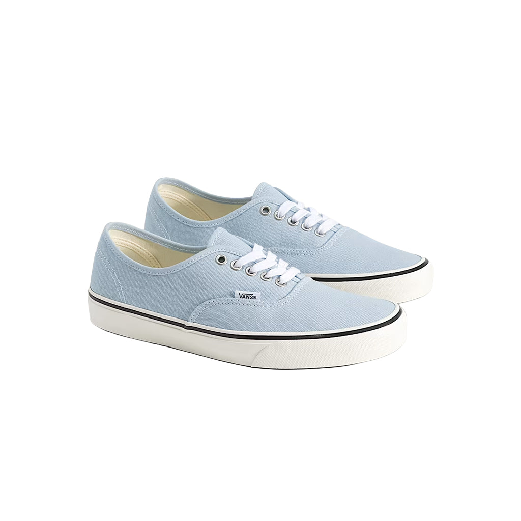 Pair of light blue sneakers with white soles on a white background