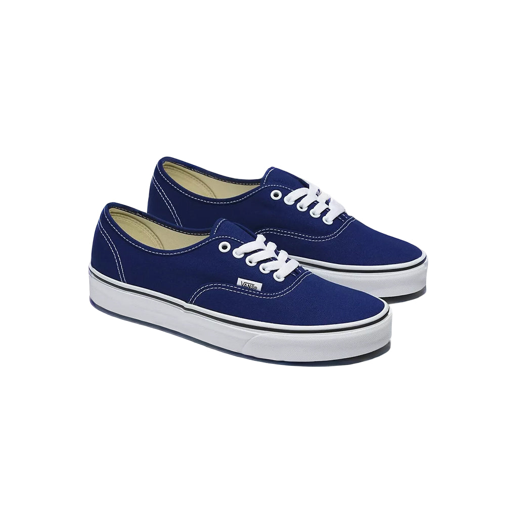 Pair of blue sneakers with white laces on a white background