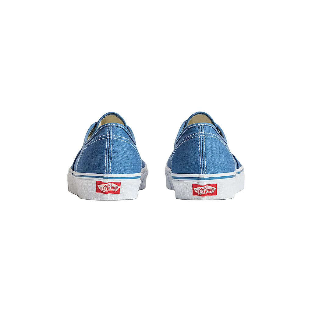 Blue Vans sneakers on a light beige background