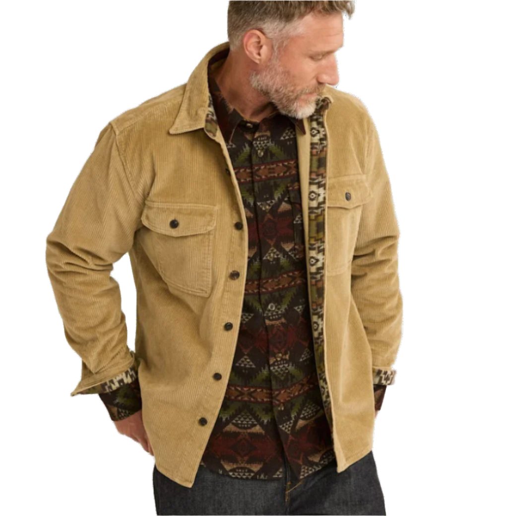 A man wearing a beige corduroy overshirt with button-through flaps on the chest pockets, neck, and cuffs, in an exclusive Pendleton pattern.