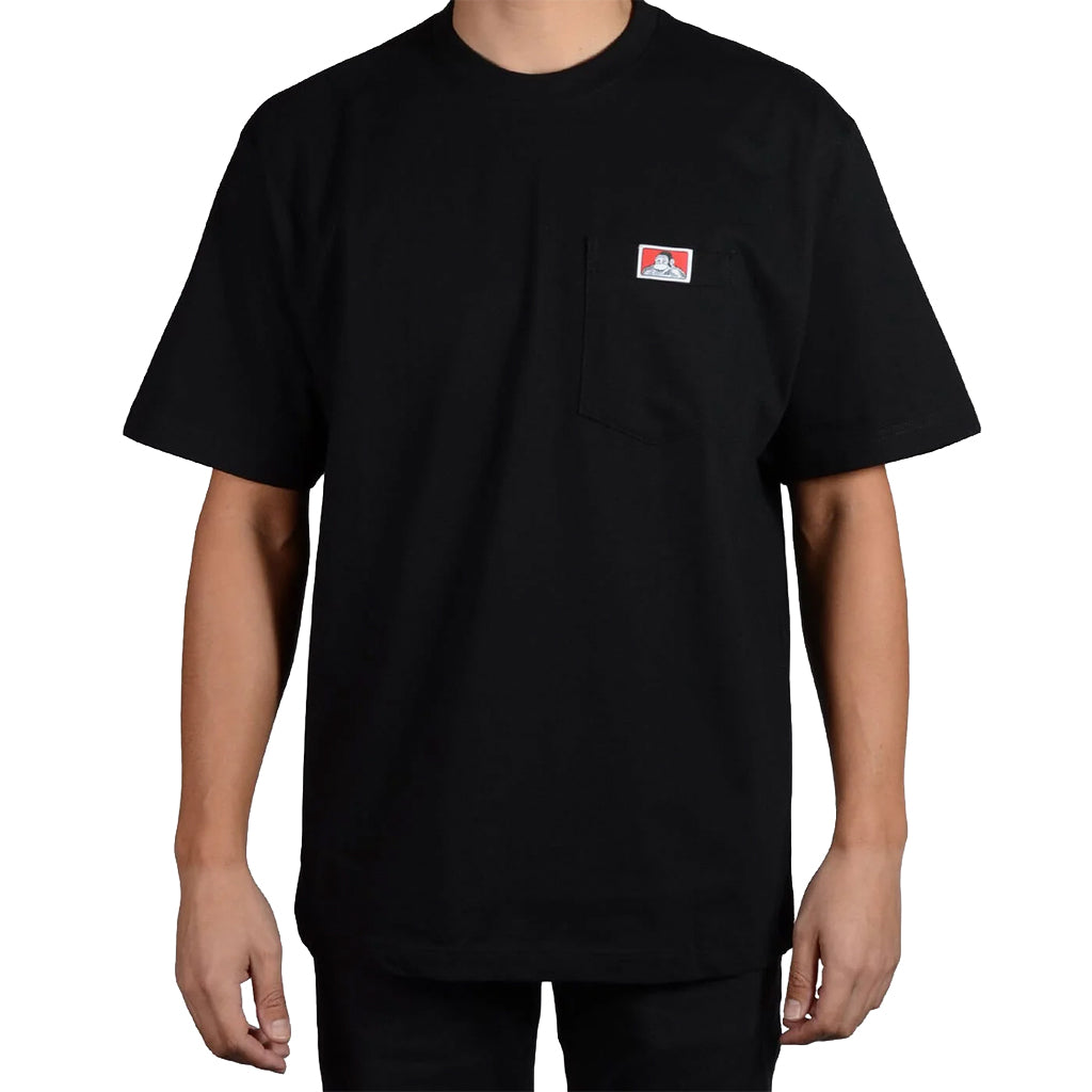Black t-shirt with a small logo on the chest worn by a person against a white background