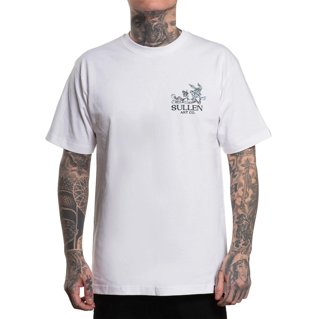White t-shirt with a logo on the chest worn by a person with tattoos.