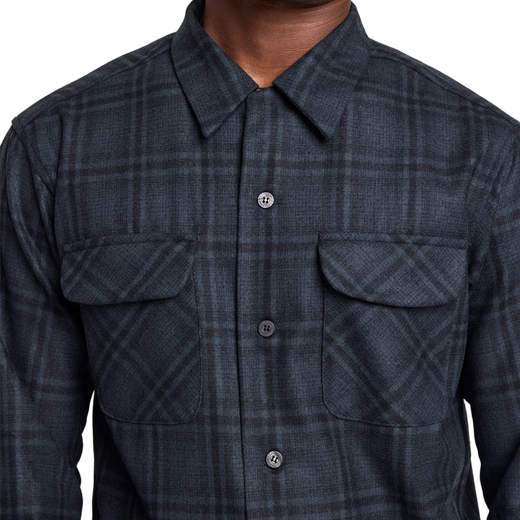 Dark plaid shirt with button details on a neutral background