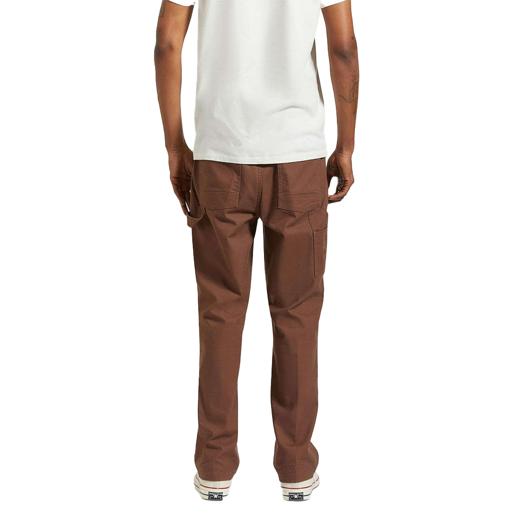Brown pants worn by a person on a white background