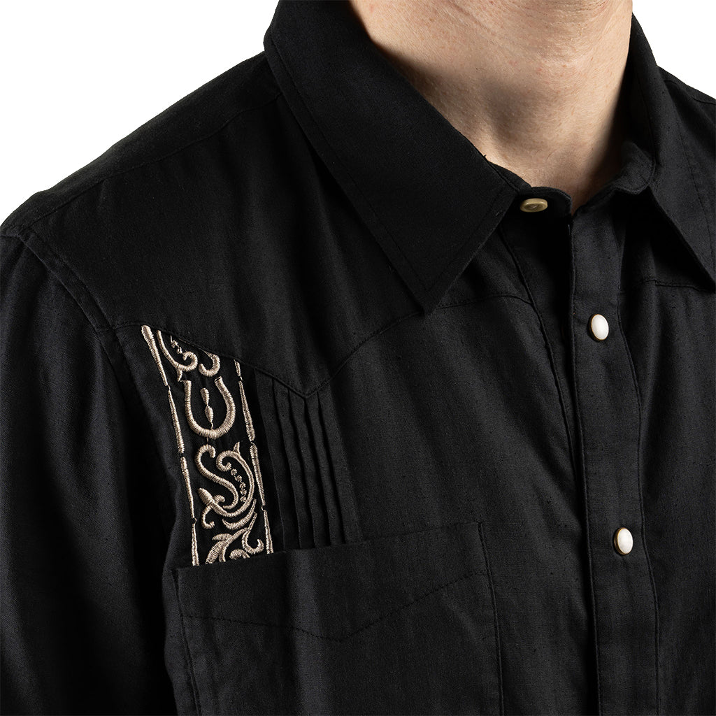 Black shirt with intricate gold embroidery on a white background