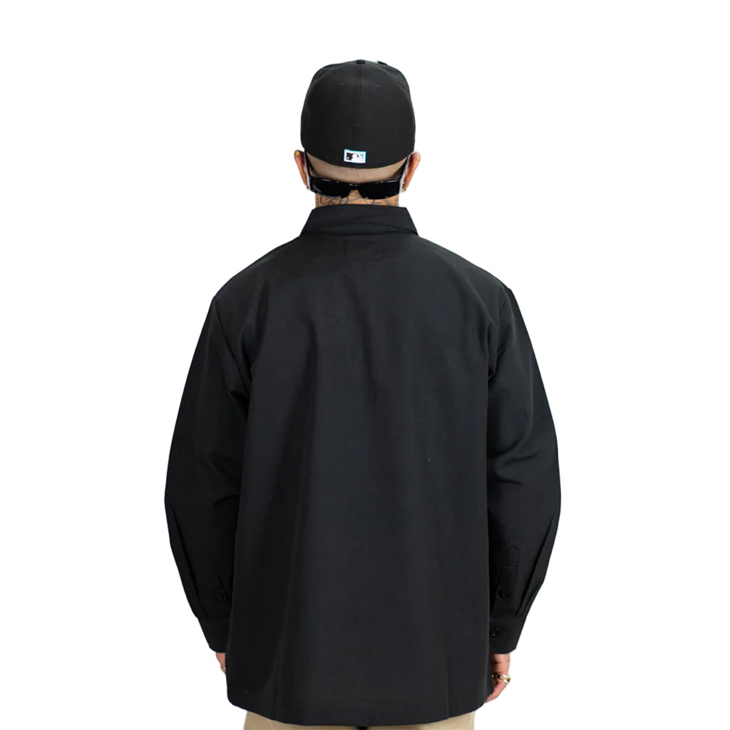 Person wearing a black jacket and cap on a white background
