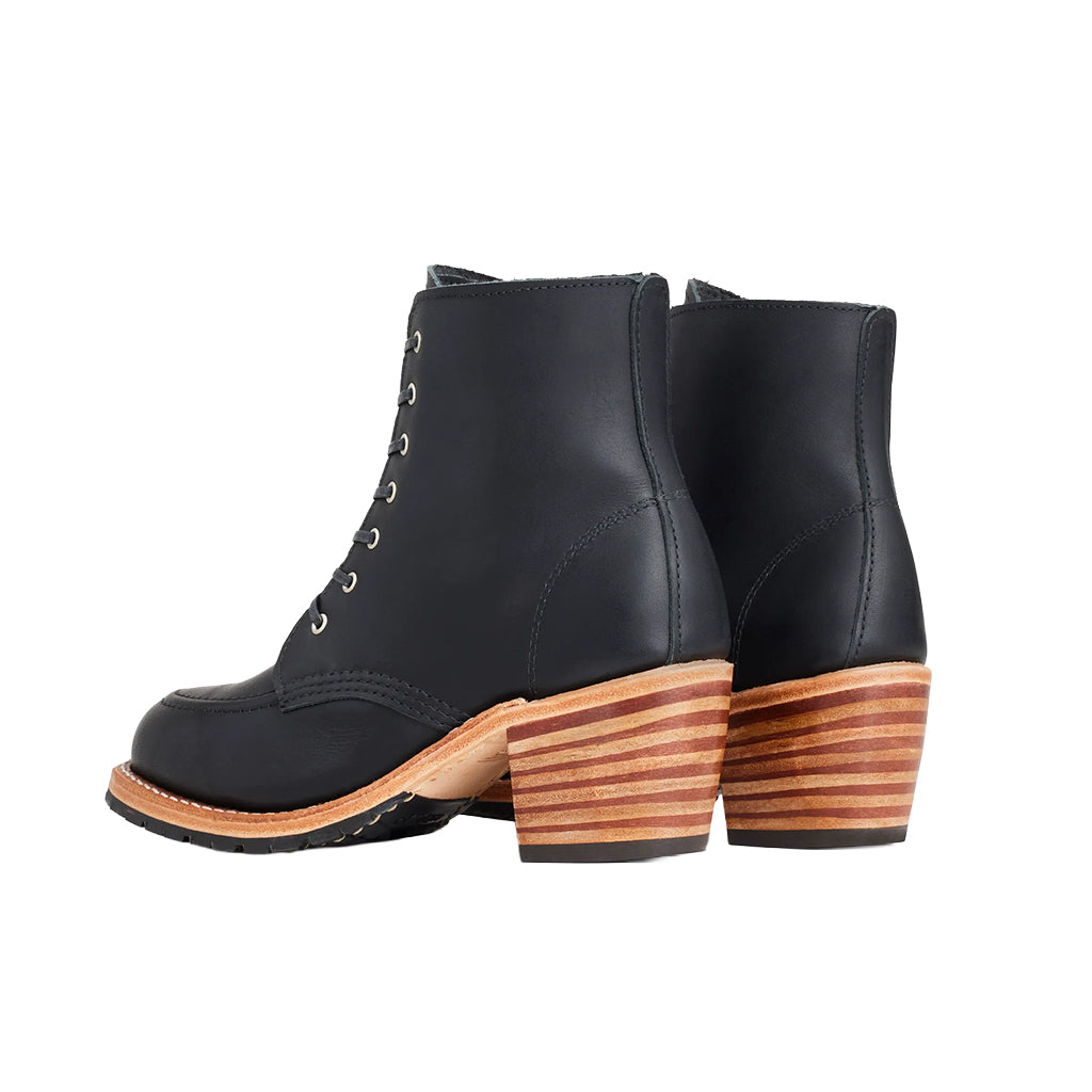 Black leather boots with wooden soles on a white background