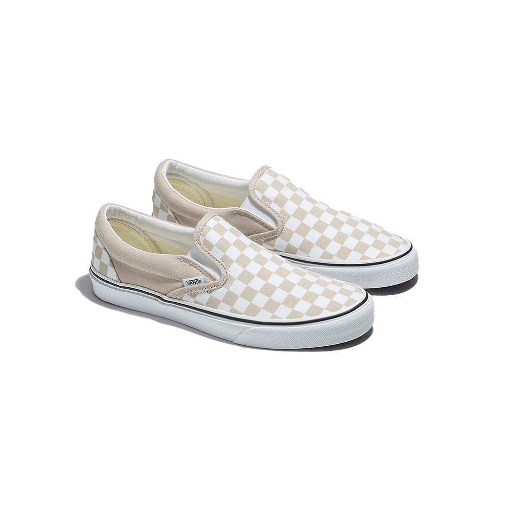 A pair of beige and white checkered slip-on sneakers.