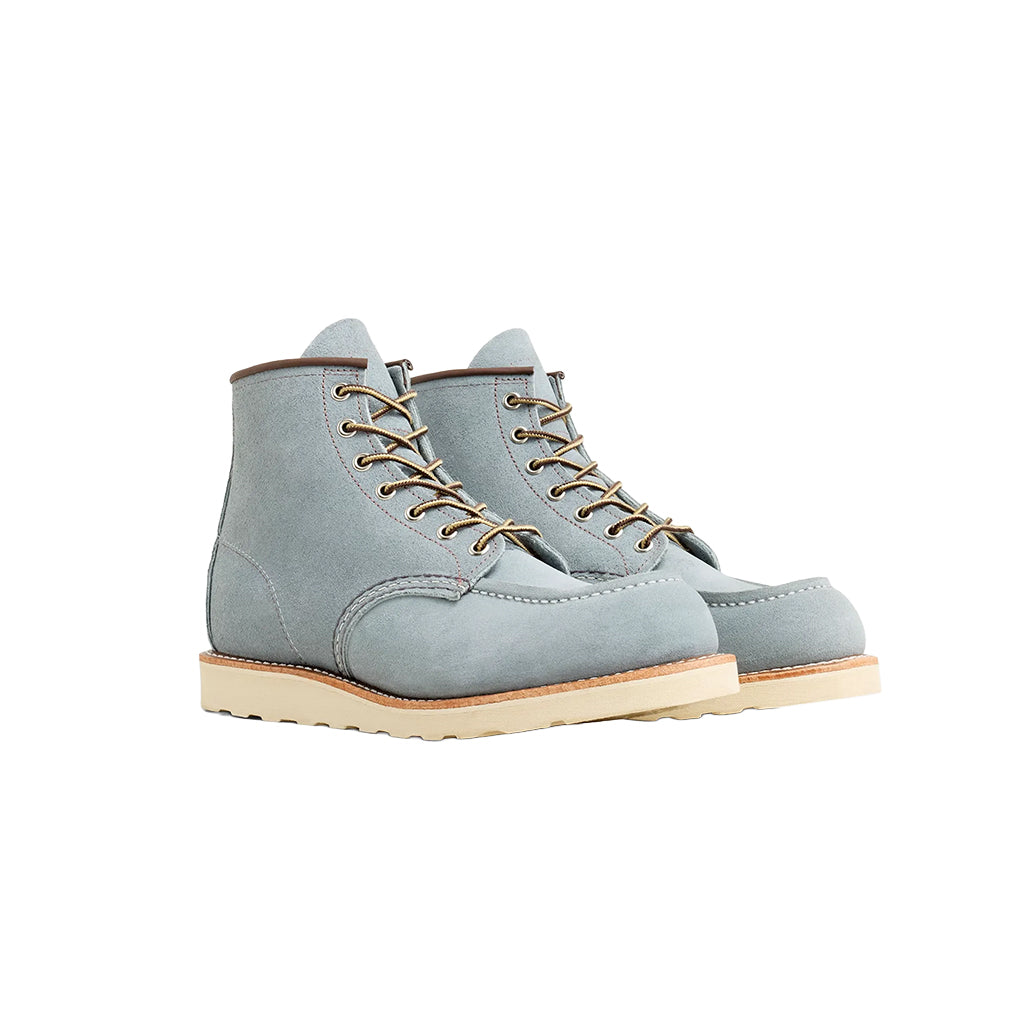 Pair of light blue boots with brown laces on a white background