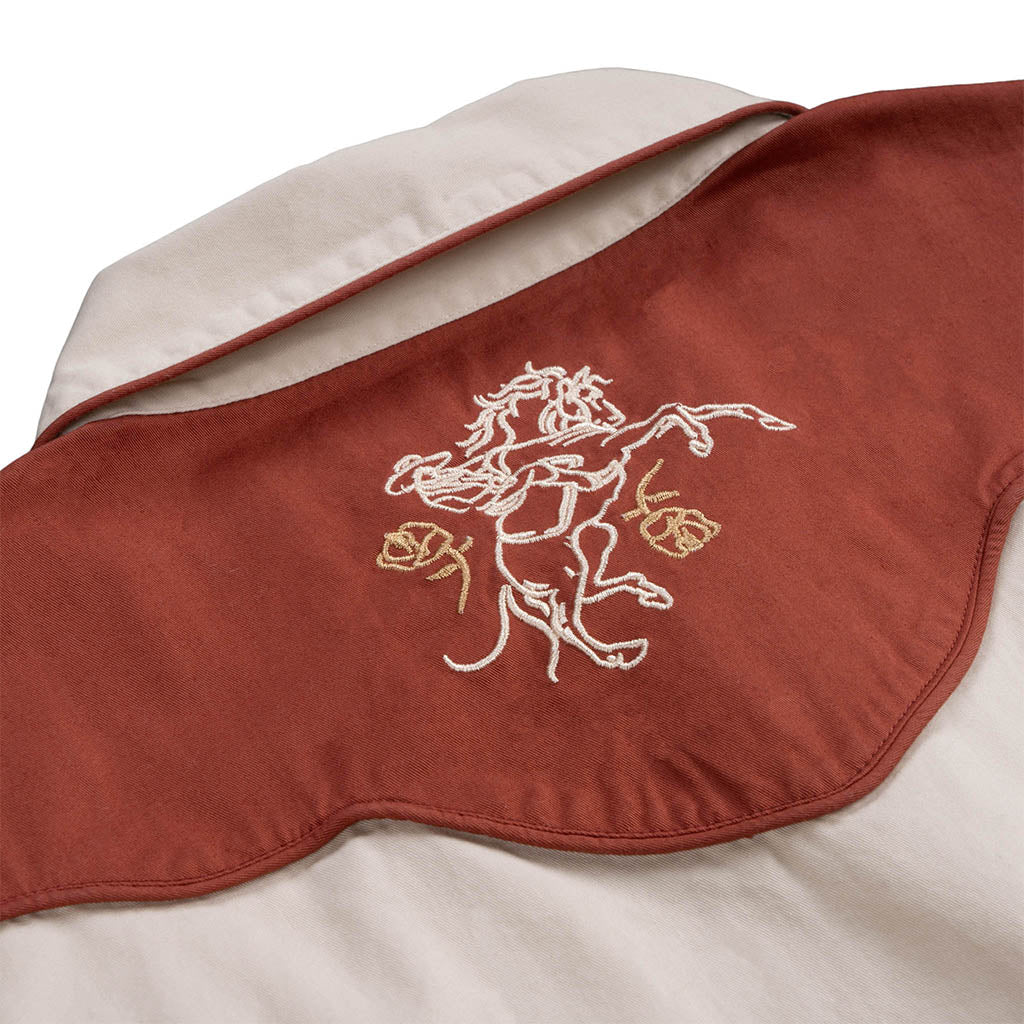Red blanket with embroidered horse design on a white background