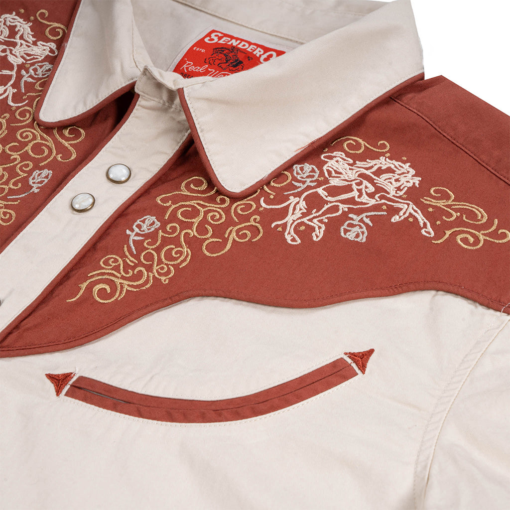 Close-up of a red and white embroidered jacket with 'Sendero' branding.
