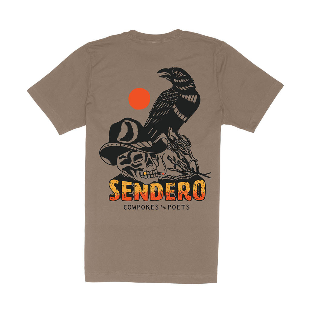 Brown t-shirt with a graphic design featuring a skull, hat, and bird, with 'Sendero' text on a white background.