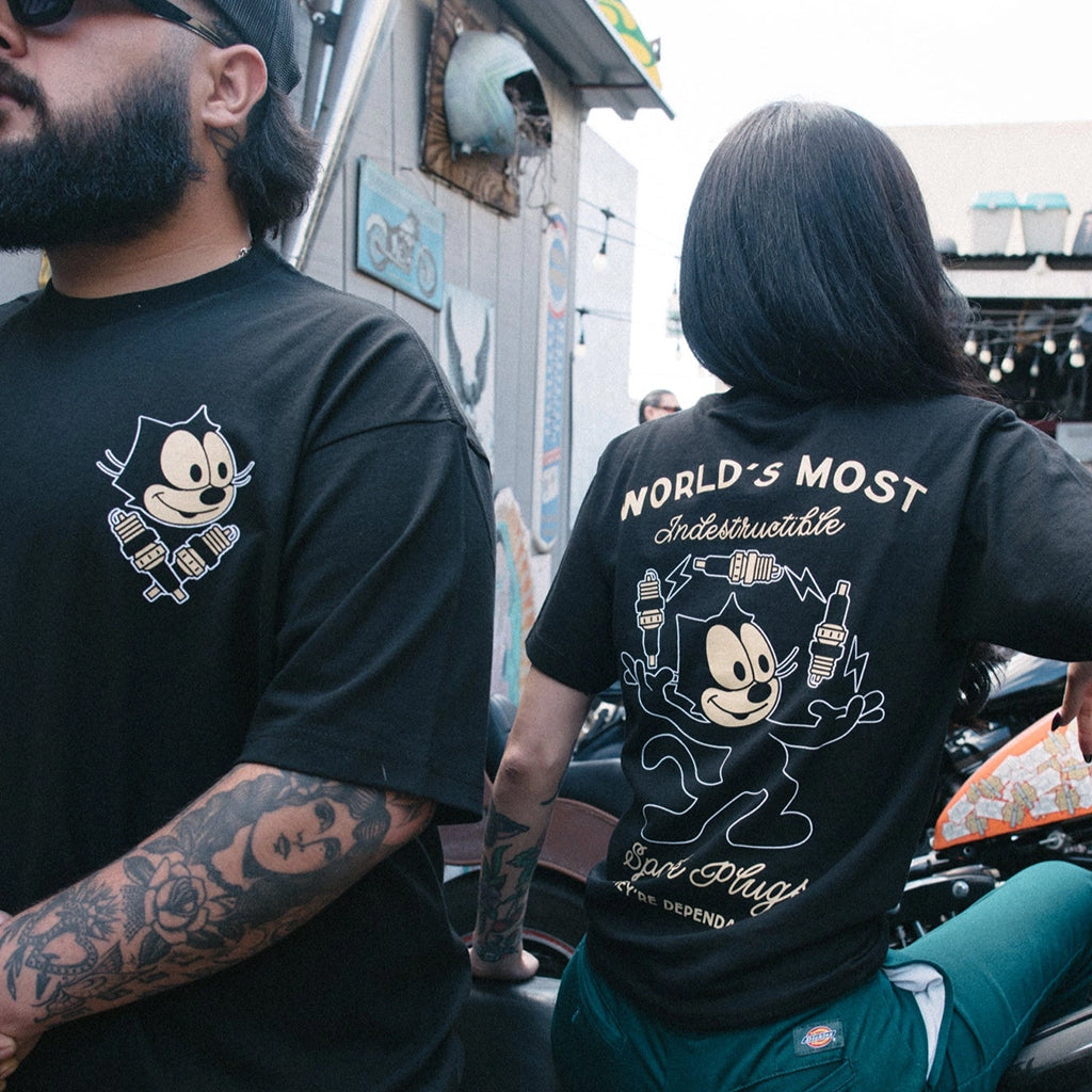 Two people wearing black t-shirts with cartoon character designs and text.