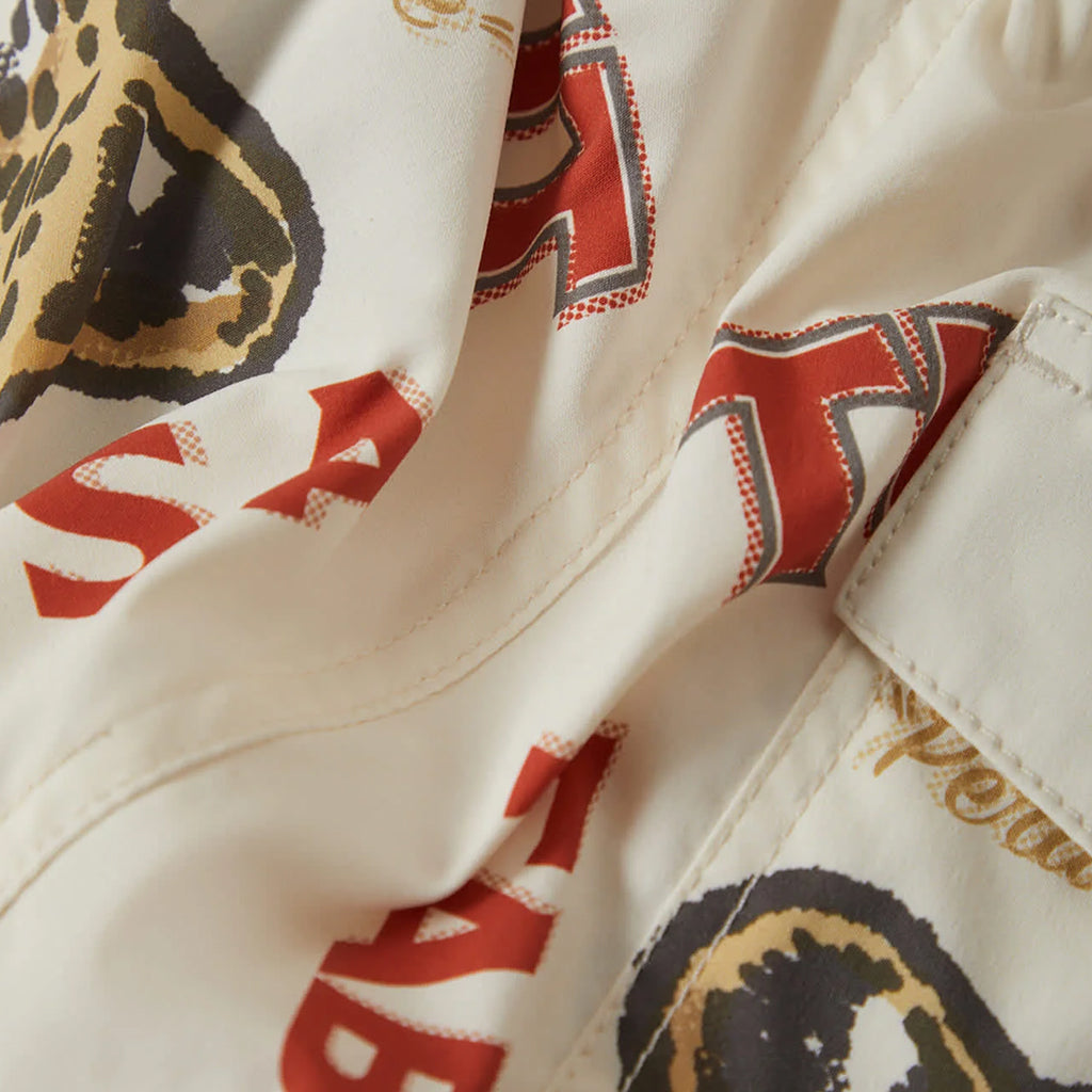 Close-up of a fabric with red and black patterns on a beige background