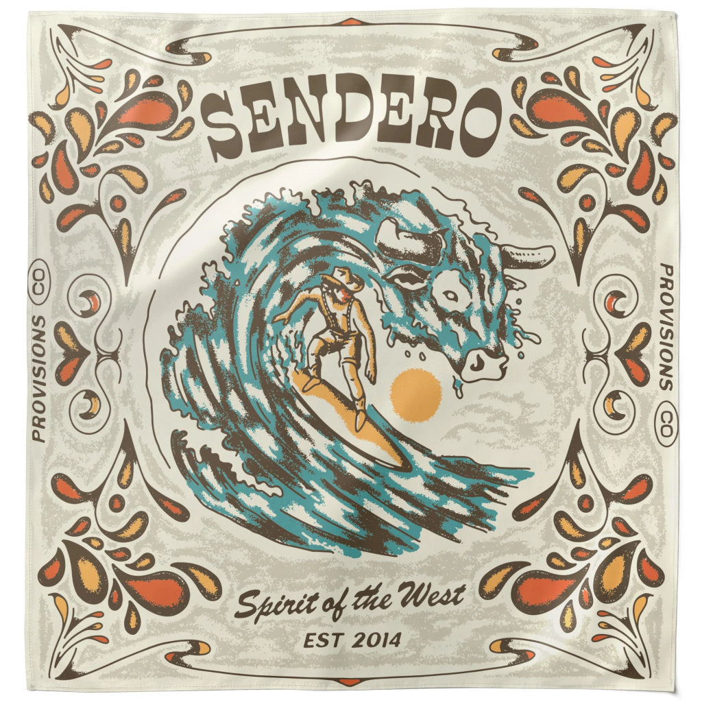 A square bandana or scarf featuring a vintage-style graphic print. The design shows a surfer riding a large blue wave with a bull's head in the background, framed by ornate orange and brown floral motifs on a light gray base.