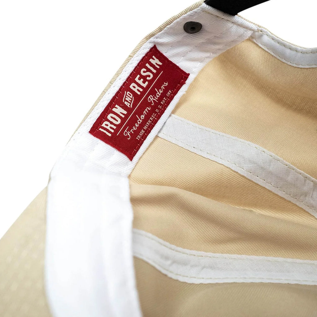 Close-up of a beige garment with a red label reading 'Iron and Resin' on a white background.