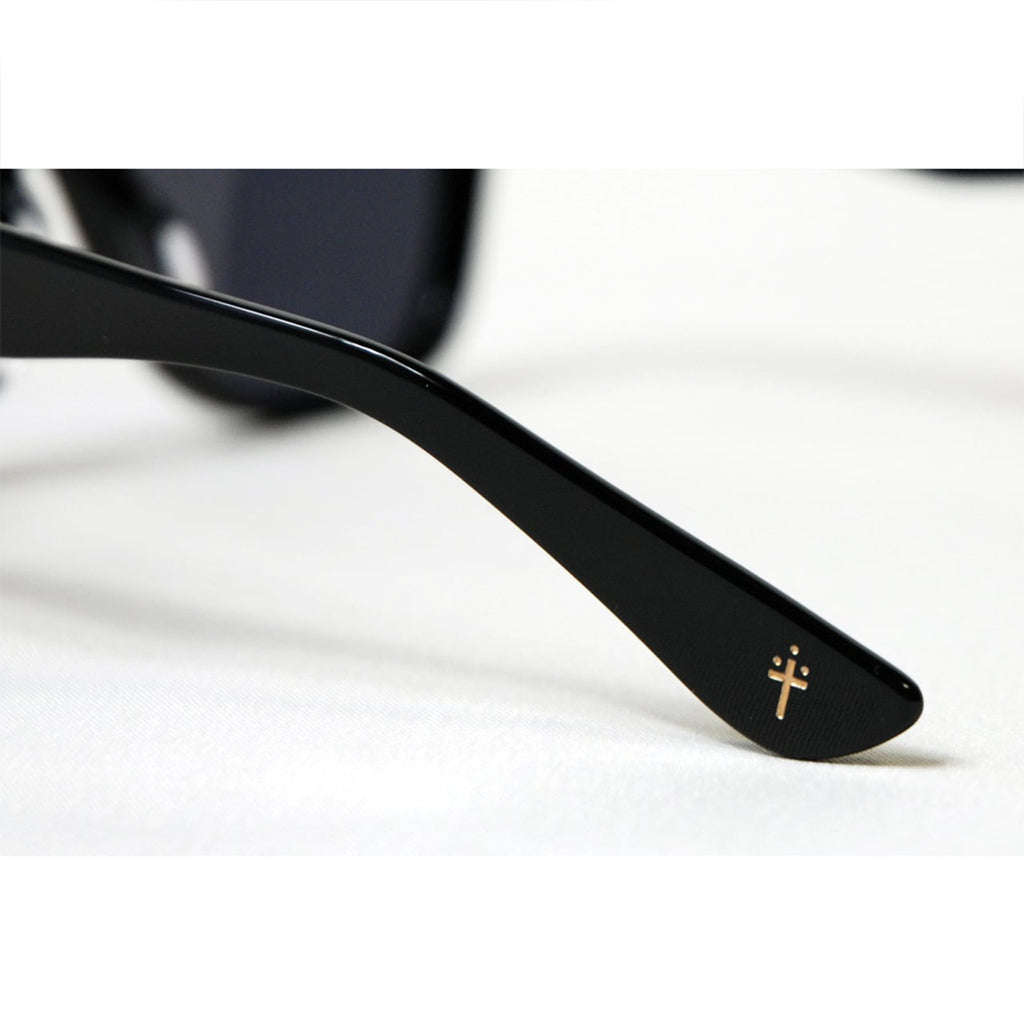 Black sunglasses with a gold logo on a white background