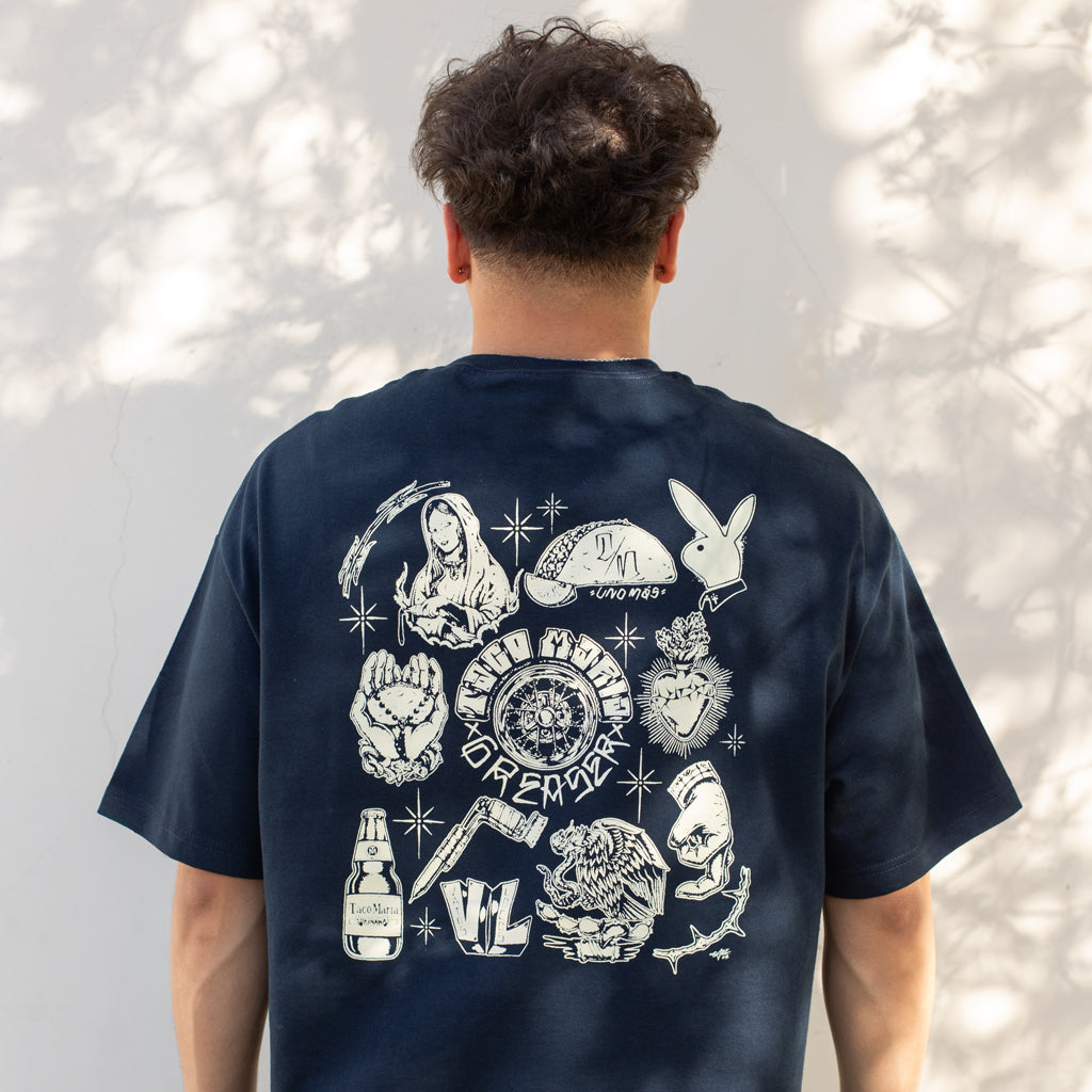 Person wearing a navy blue t-shirt with white graphic designs on the back against a light gray background