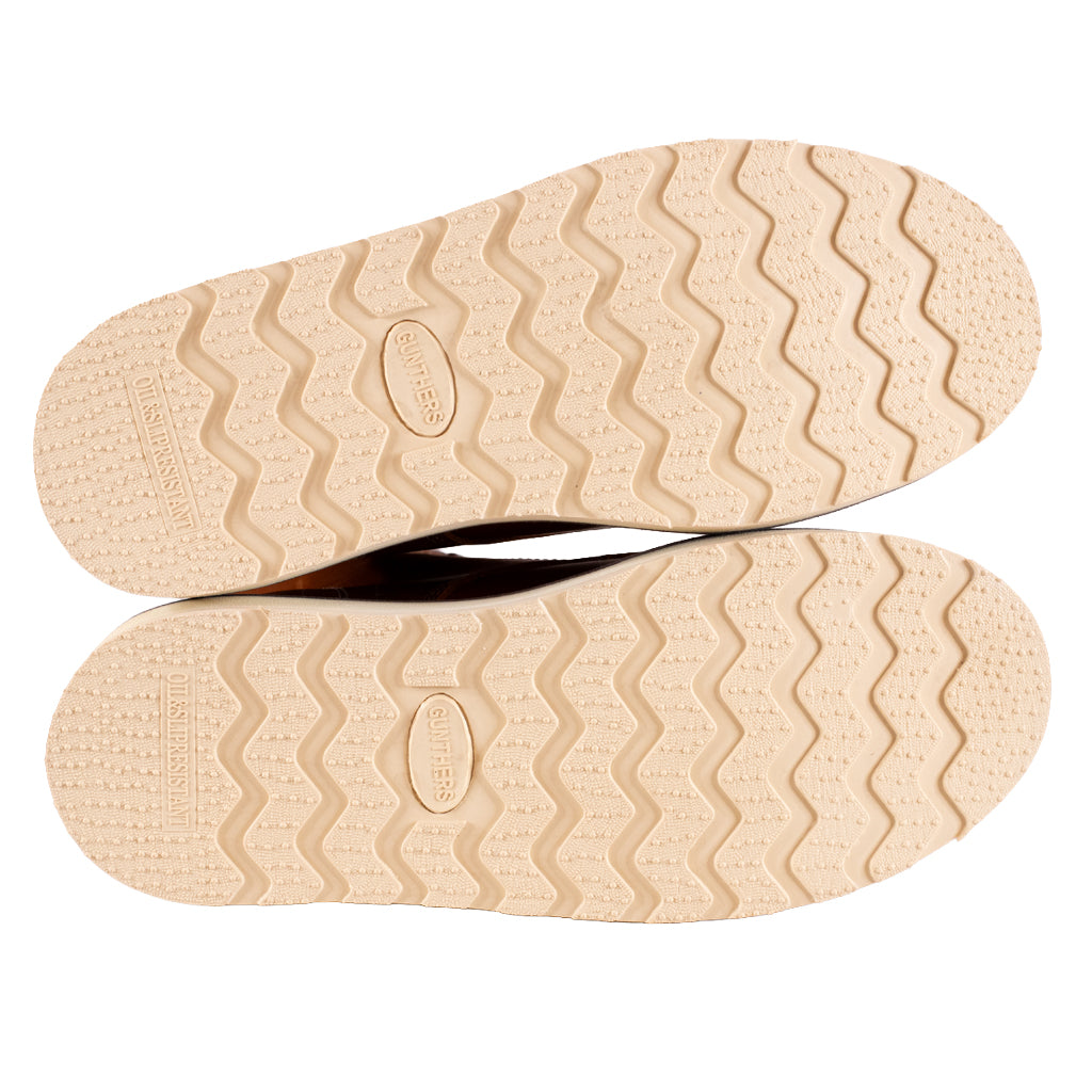 Beige shoe soles with a textured pattern on a white background
