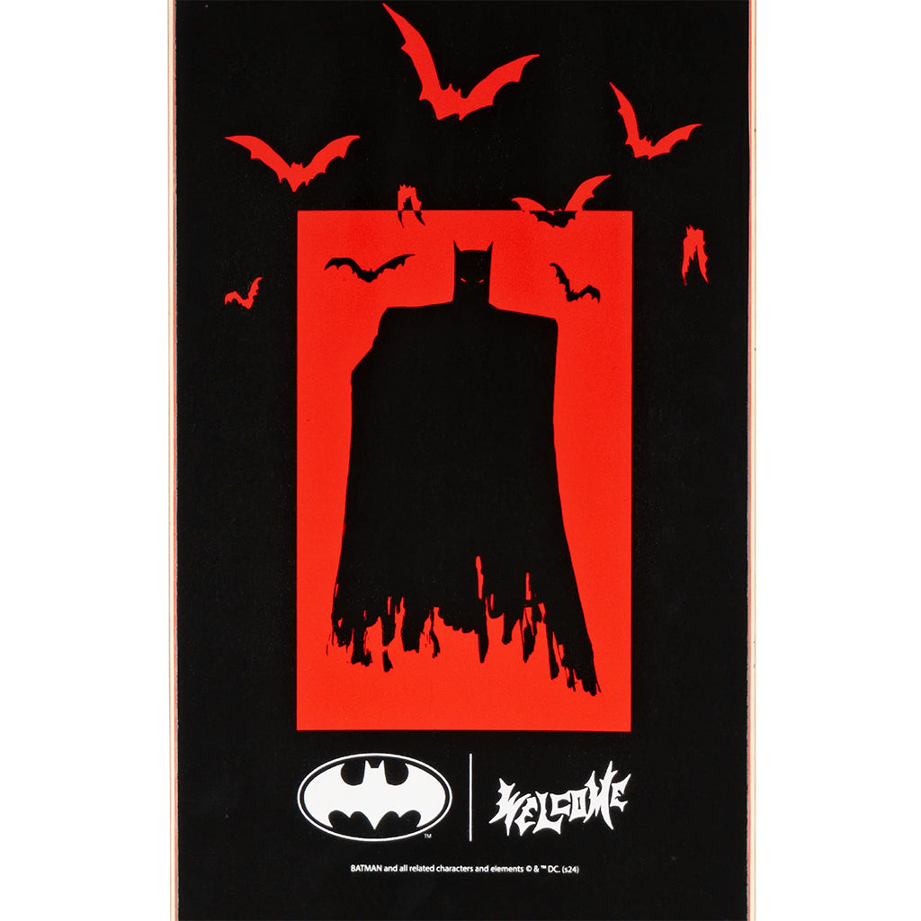 Batman silhouette with red background and flying bats on a black skateboard deck.