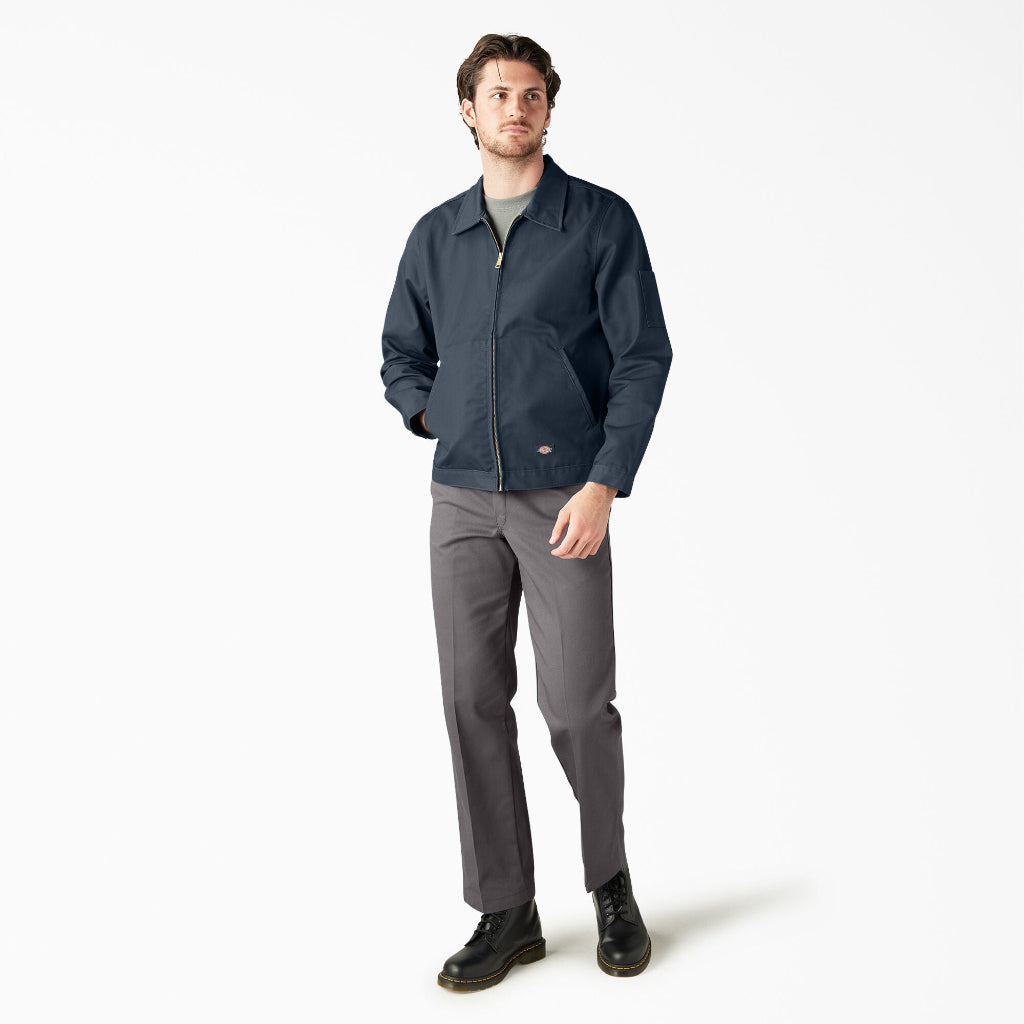 Man wearing a navy jacket and gray pants on a white background