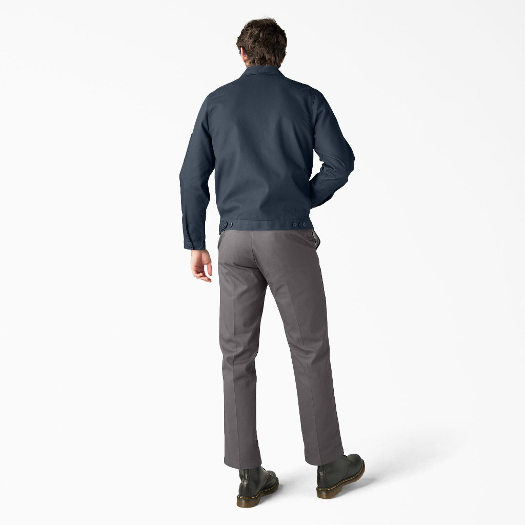 Man wearing a navy jacket and gray pants on a white background