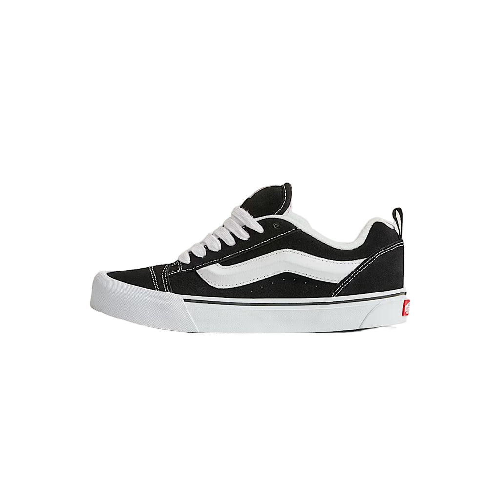 Black and white sneaker on a light beige background