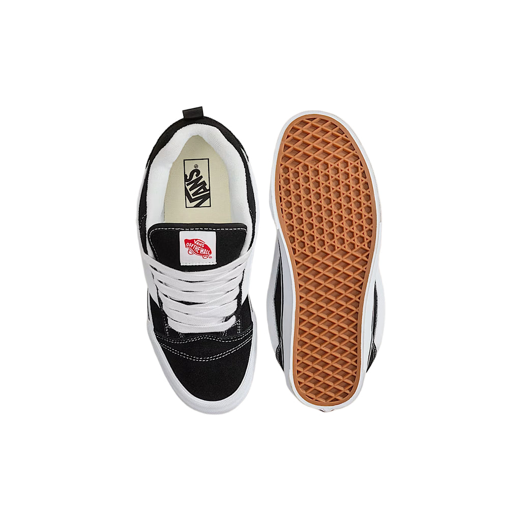 Black and white sneaker with brown sole on a white background