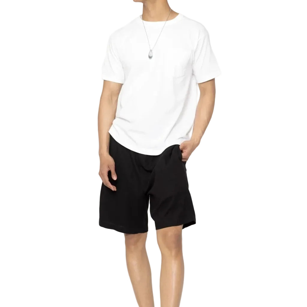 Man wearing a white t-shirt and black shorts on a white background