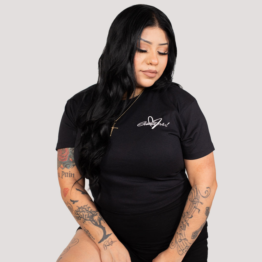 Woman wearing a black t-shirt with a logo on a gray background