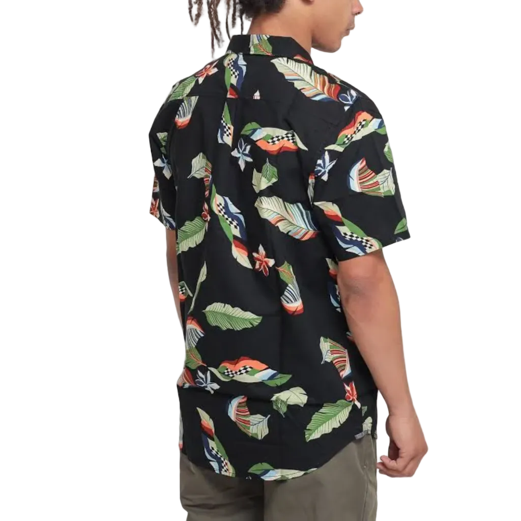 A man shown from the back wearing a black short-sleeve button-up shirt with a colorful tropical leaf and fish print, paired with olive green pants, set against a plain white background.
