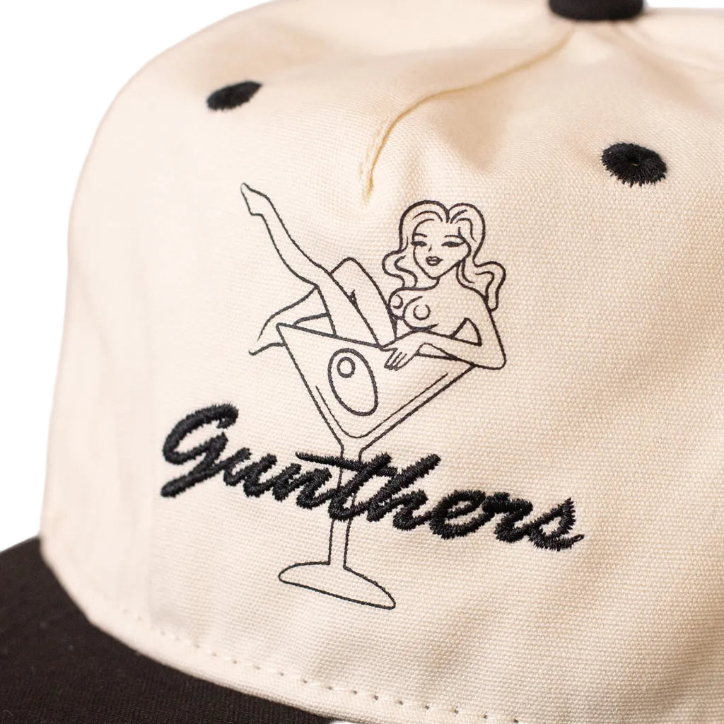 Cap with embroidered design of a woman in a martini glass and 'Gunthers' text.
