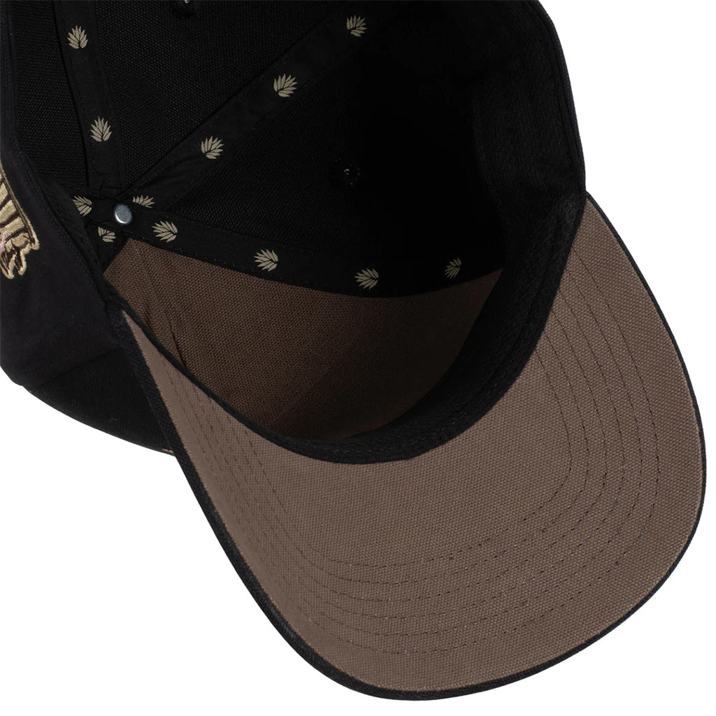 Close-up of a black and brown cap with decorative elements on a white background