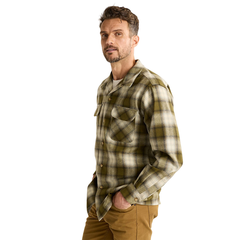 Man wearing a plaid shirt and brown pants on a white background