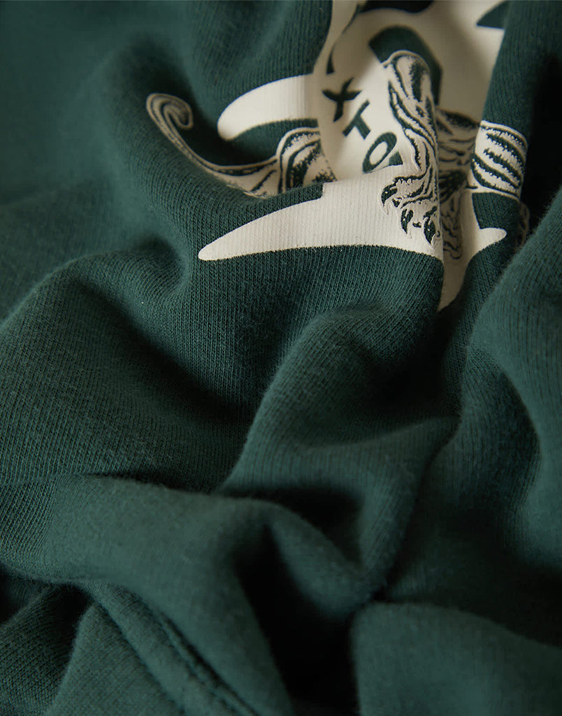 Close-up of a green garment with a white and black logo.