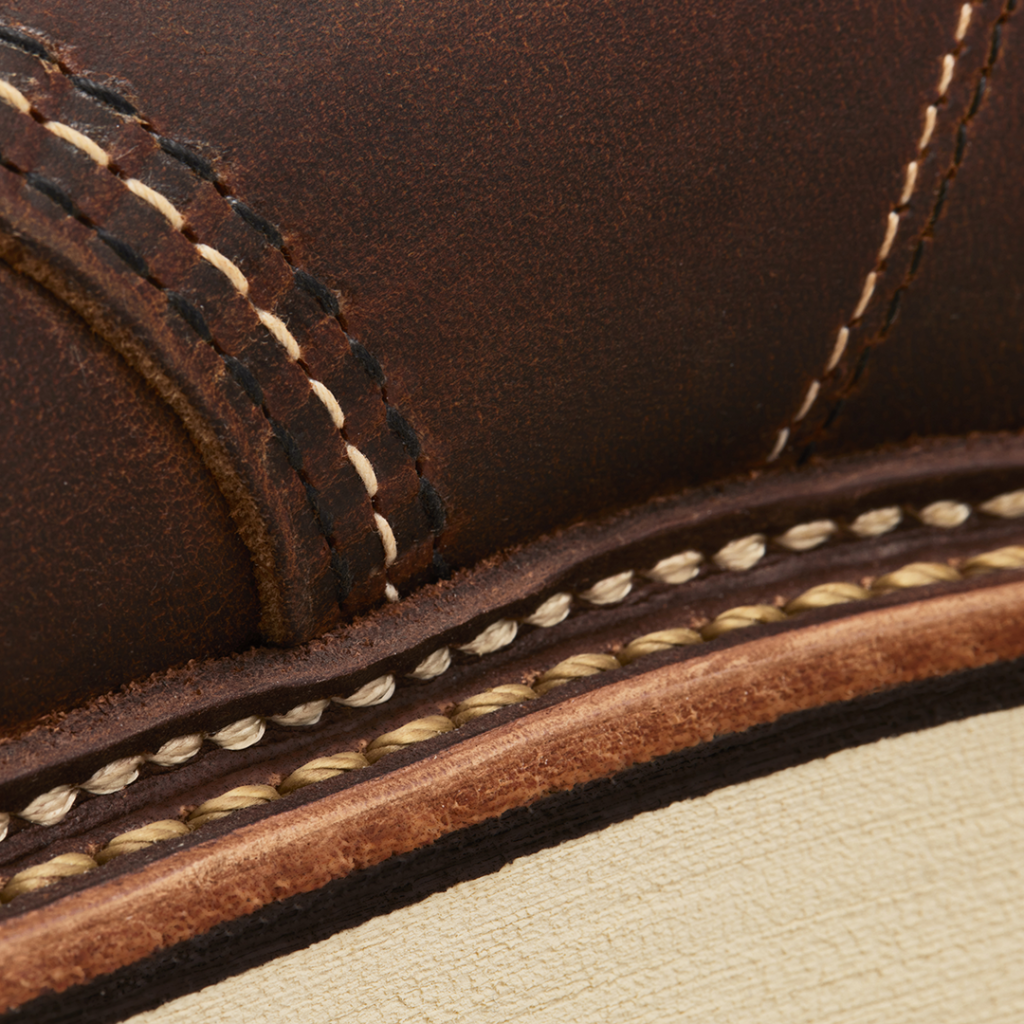 Close-up of brown leather bot with white stitching